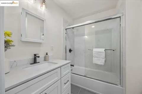 a bathroom with a granite countertop sink a toilet a shower and a mirror