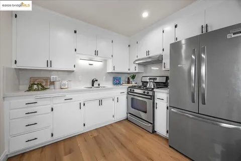 a kitchen with stainless steel appliances white cabinets and a refrigerator