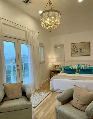 a bedroom with a bed couch and chandelier