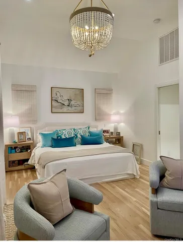 a bedroom with a bed and a chandelier