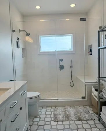 a bathroom with a granite countertop sink a toilet and a shower