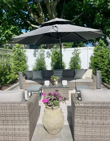 a view of a patio with table and chairs under an umbrella