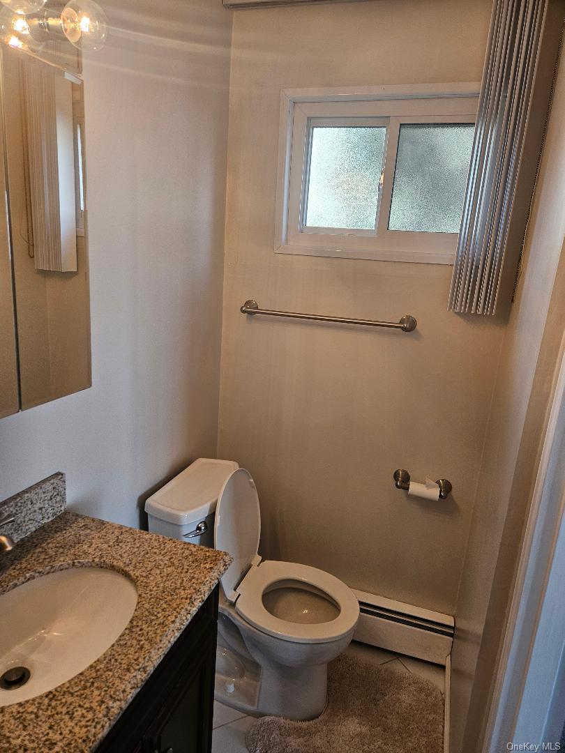 149 Truxton Road Dix Hills, NY 11746 - Photo 20 of 22 Bathroom featuring vanity, baseboard heating, and tile patterned floors