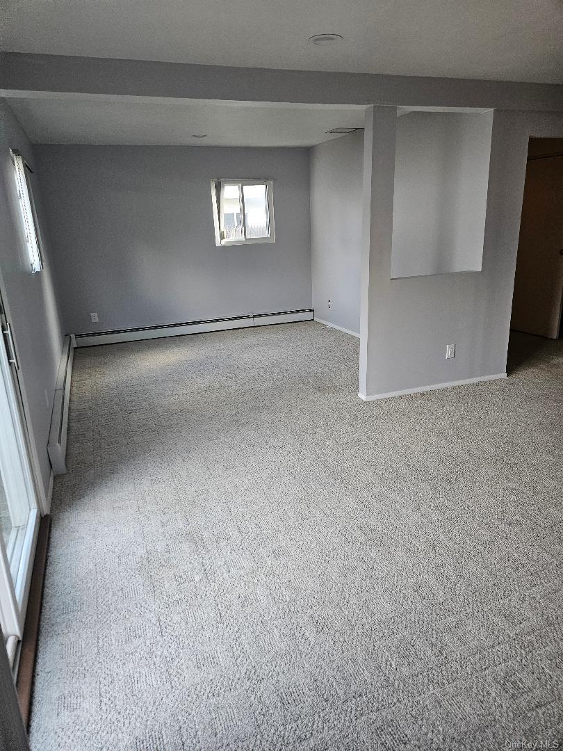 149 Truxton Road Dix Hills, NY 11746 - Photo 5 of 22 Carpeted spare room featuring baseboards and a baseboard radiator