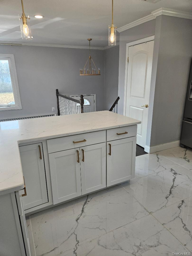 149 Truxton Road Dix Hills, NY 11746 - Photo 10 of 22 Kitchen with light marble finish floors, light stone counters, crown molding, hanging light fixtures, and fridge with ice dispenser