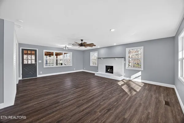 an empty room with windows and fireplace