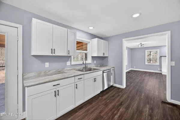 a kitchen with sink cabinets and wooden floor