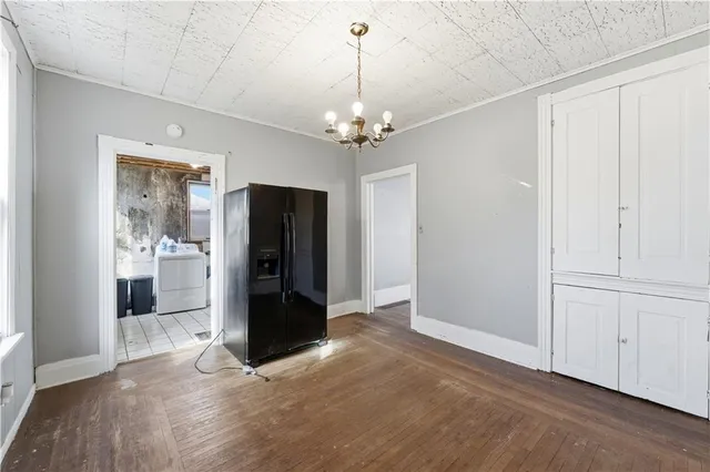 a view of a livingroom with a chandelier fan and windows