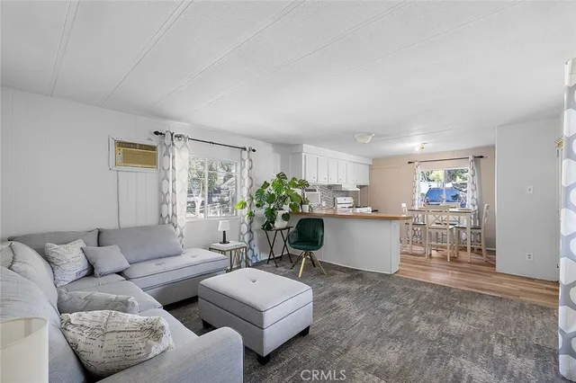 a living room with furniture and view of kitchen