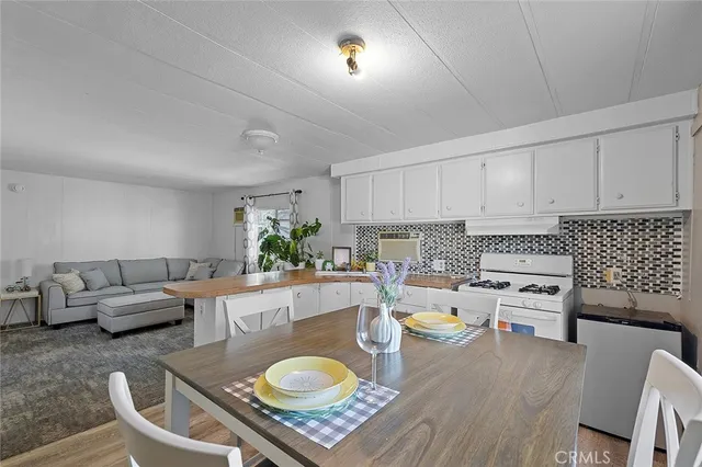 a living room with furniture and a dining table with rug