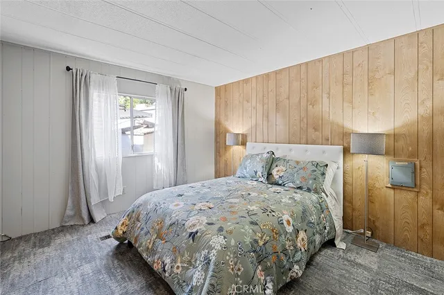 a bed sitting in a spacious bedroom next to a window