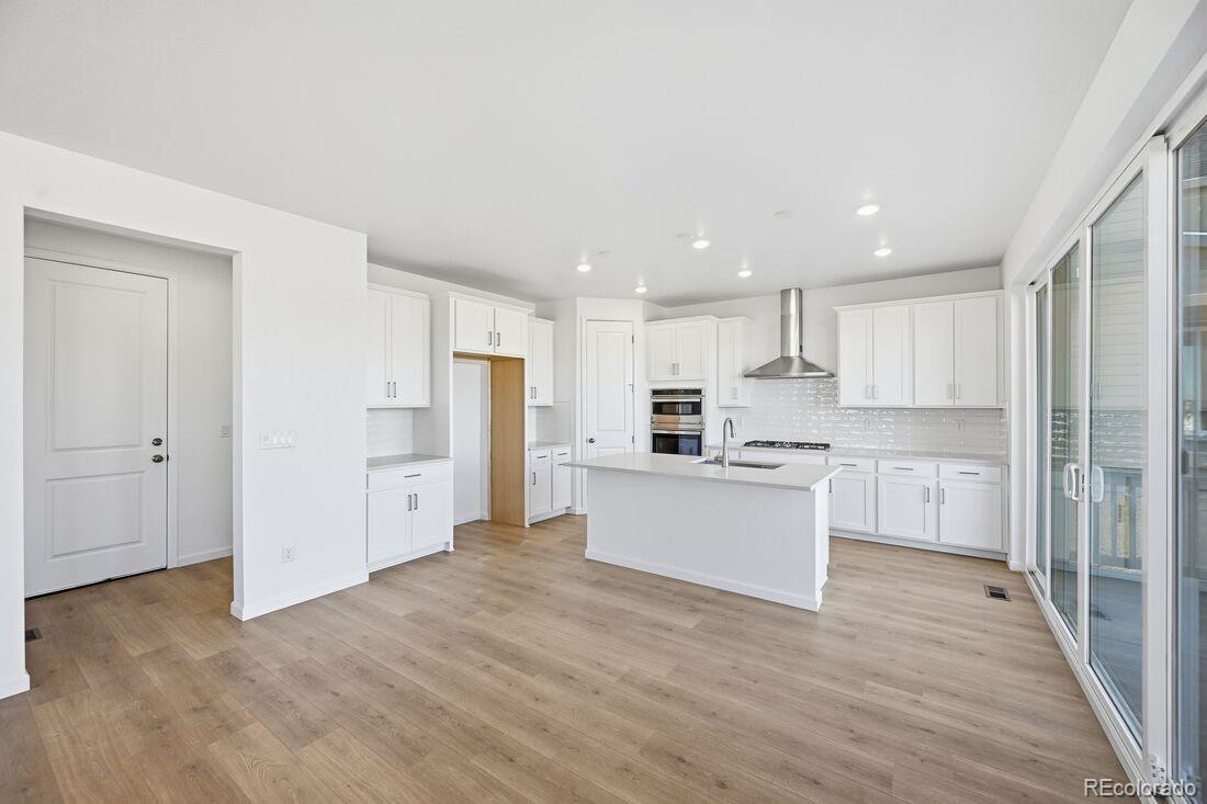 16857 West 92nd Loop Arvada, CO 80007 - Photo 12 of 31 a kitchen with white cabinets and stainless steel appliances