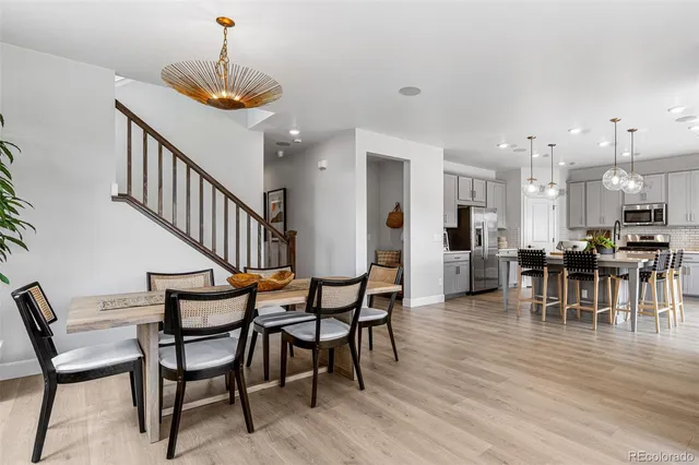 a view of a dining room and livingroom with furniture wooden floor a chandelier