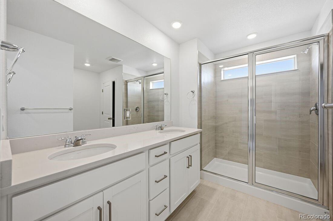 16857 West 92nd Loop Arvada, CO 80007 - Photo 17 of 31 a bathroom with a shower sink double and mirror
