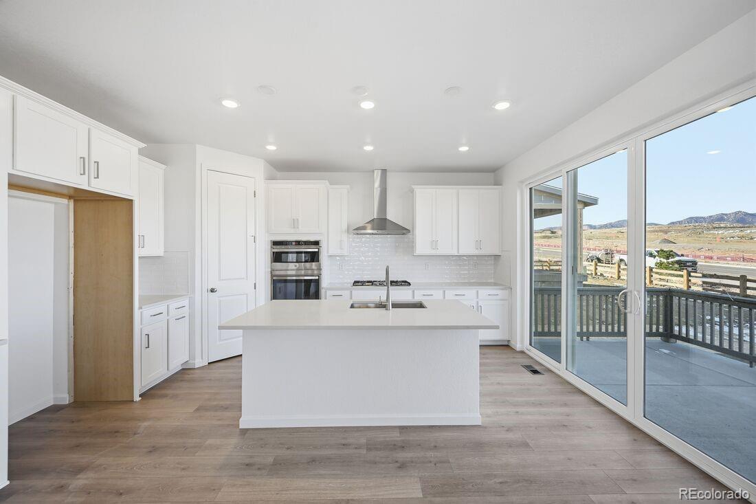 16857 West 92nd Loop Arvada, CO 80007 - Photo 2 of 31 a large kitchen with stainless steel appliances kitchen island granite countertop a refrigerator and a stove top oven