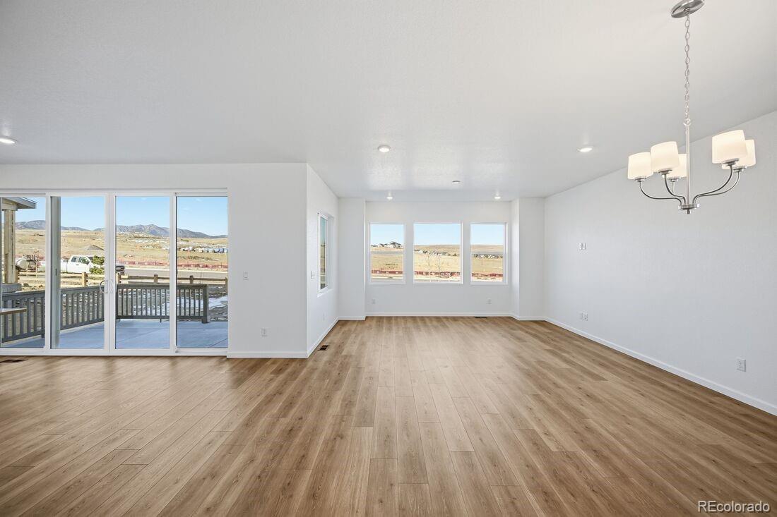 16857 West 92nd Loop Arvada, CO 80007 - Photo 4 of 31 an empty room with wooden floor and windows