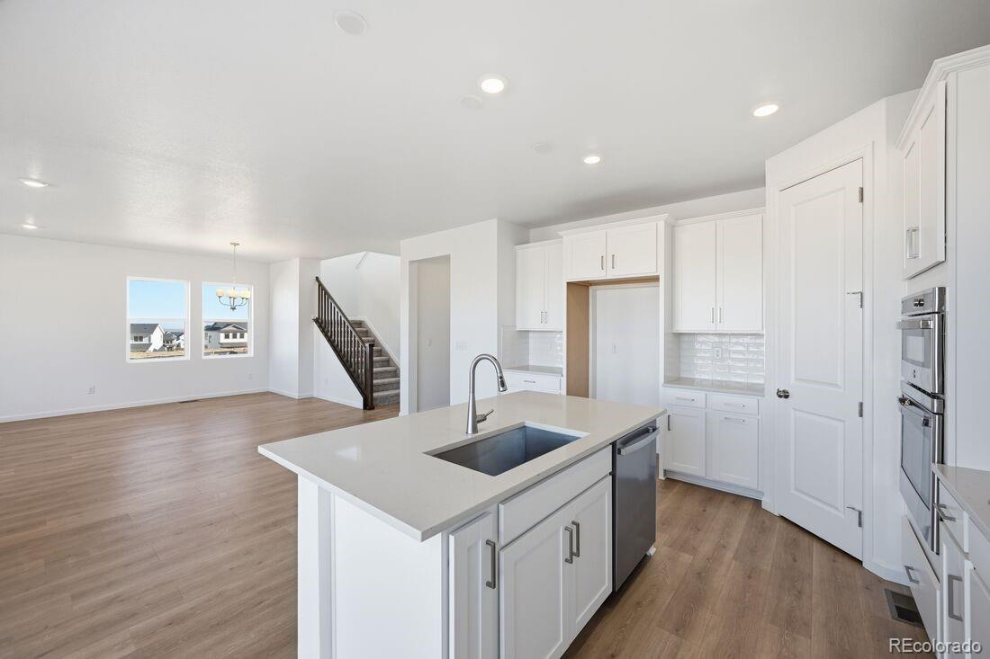 16857 West 92nd Loop Arvada, CO 80007 - Photo 5 of 31 a kitchen with white cabinets and refrigerator