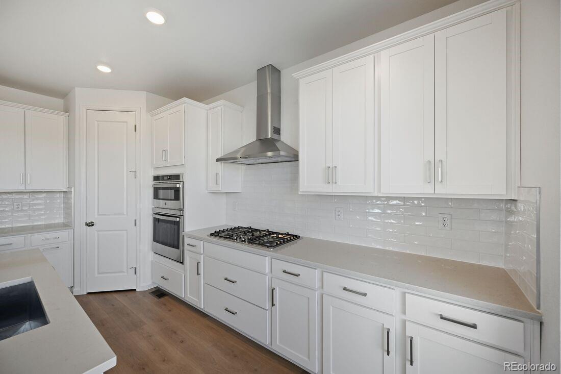 16857 West 92nd Loop Arvada, CO 80007 - Photo 6 of 31 a kitchen with white cabinets and appliances