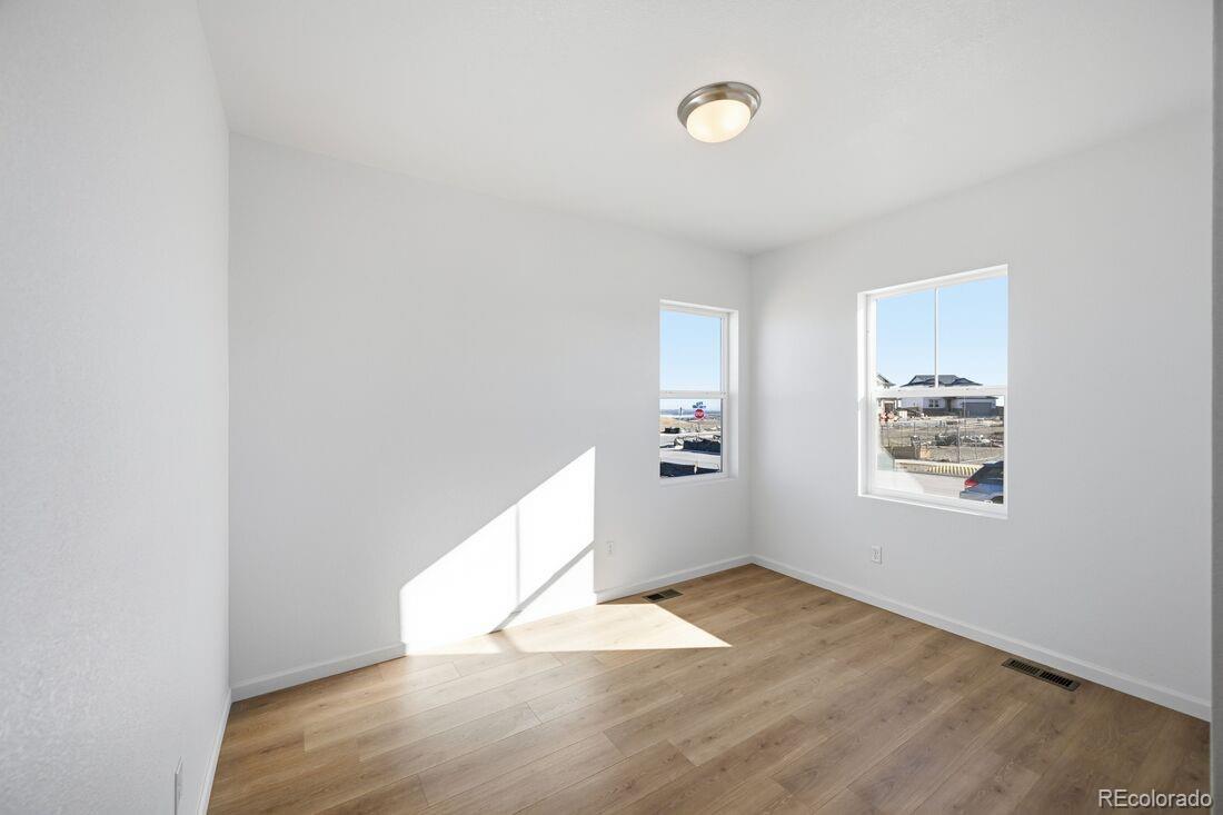 16857 West 92nd Loop Arvada, CO 80007 - Photo 7 of 31 an empty room with wooden floor and windows