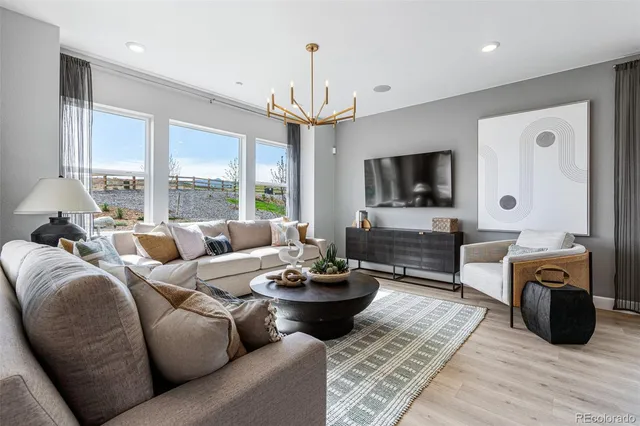 a living room with furniture a dining table and a chandelier