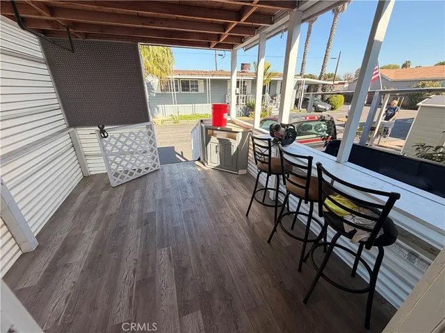 an outdoor sitting area with couch and wooden floor