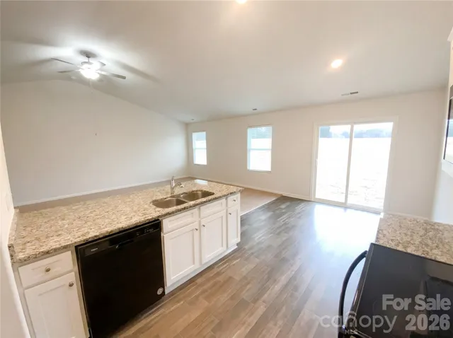 a kitchen with granite countertop a stove a sink and a microwave