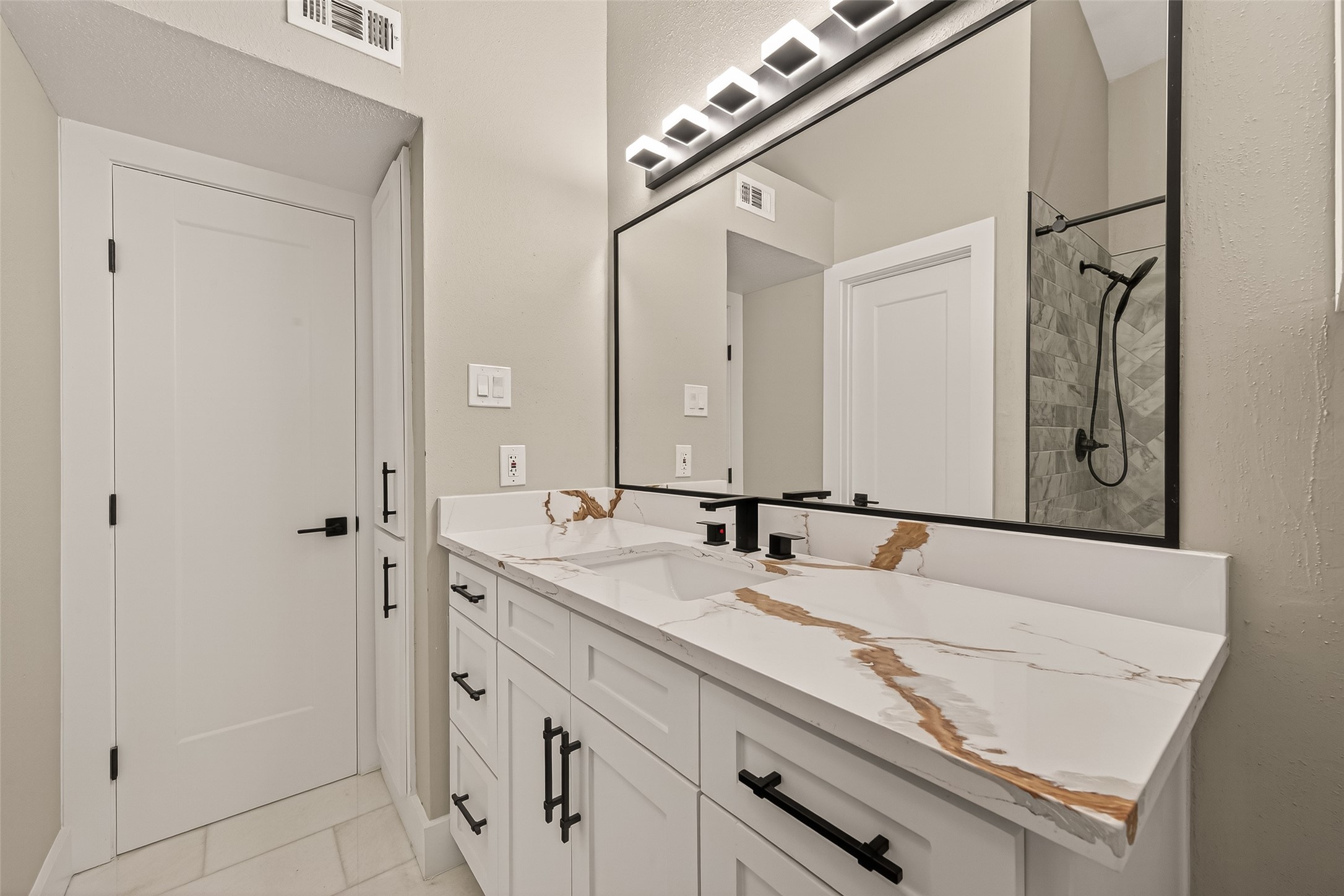 6750 Sands Point Drive Houston, TX 77074 - Photo 30 of 39 Oversize quartz counters, framed mirror and modern light fixture.