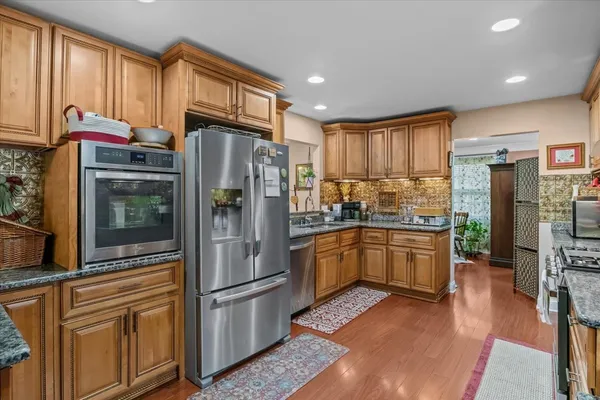 a kitchen with stainless steel appliances granite countertop a refrigerator stove and cabinets