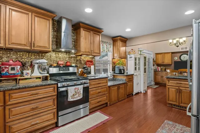 a kitchen with stainless steel appliances granite countertop a stove and cabinets