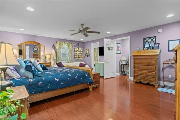 a spacious bedroom with a bed and wooden floor