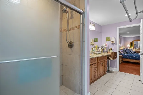 a en suite bathroom with a granite countertop sink and a mirror