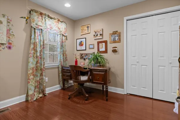 a view of a workspace with furniture and a window