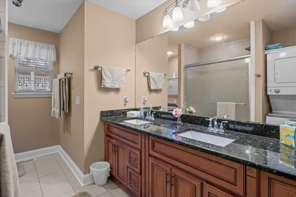 a bathroom with a granite countertop sink a toilet a mirror and shower