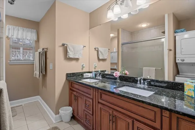 a bathroom with a granite countertop sink a toilet a mirror and shower