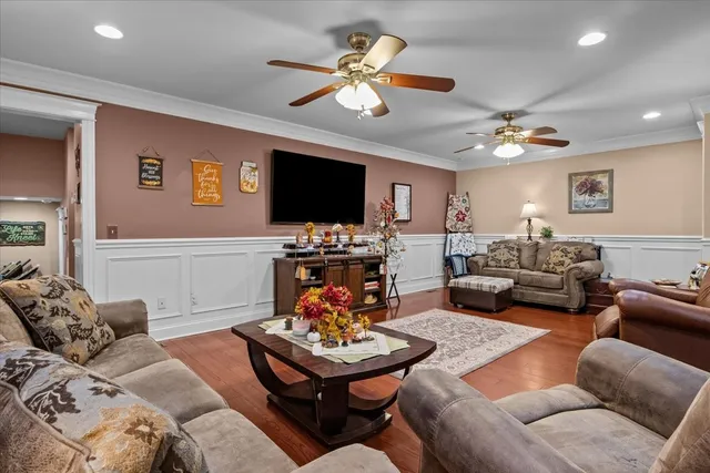 a living room with furniture kitchen view and a flat screen tv
