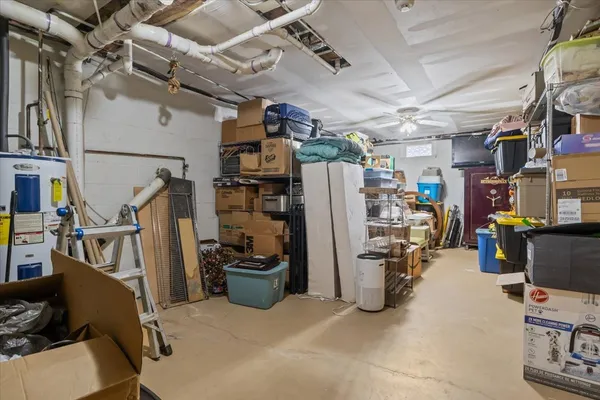 a view of a white house with a wooden bench next to a road