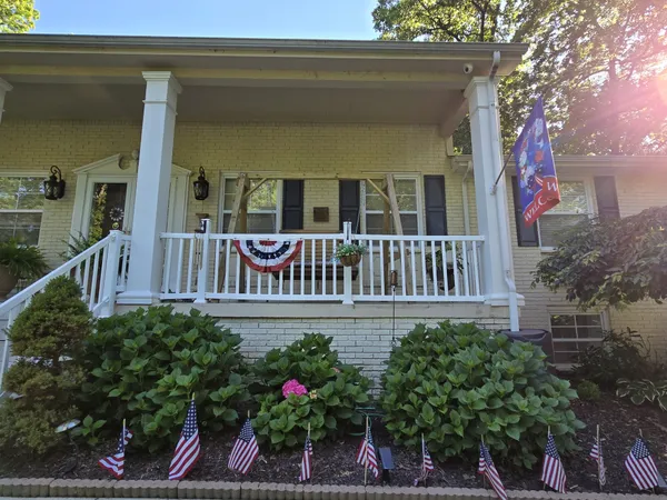 a view of a house with a cars park side of a road