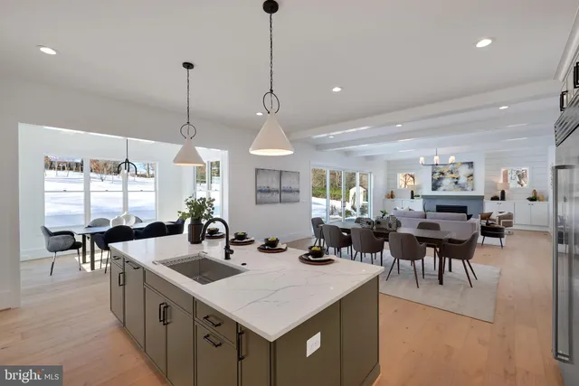 a kitchen with stainless steel appliances kitchen island granite countertop a sink a stove and refrigerator