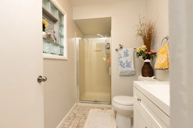 a bathroom with a sink a toilet and shower