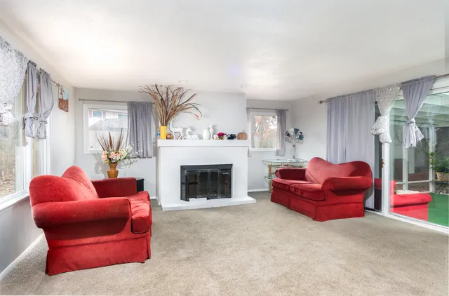 a living room with furniture fireplace and a window