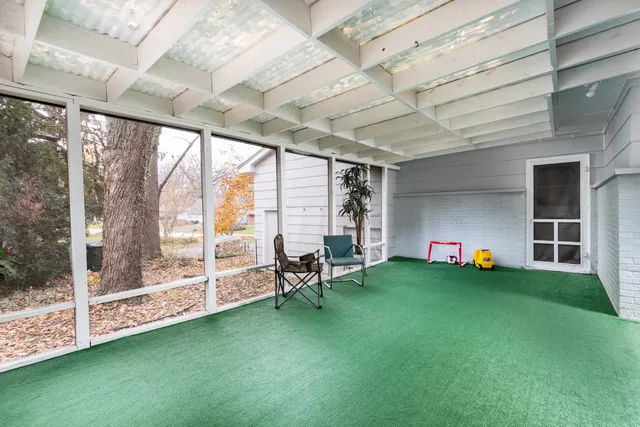 a living room with furniture floor to ceiling window and garden
