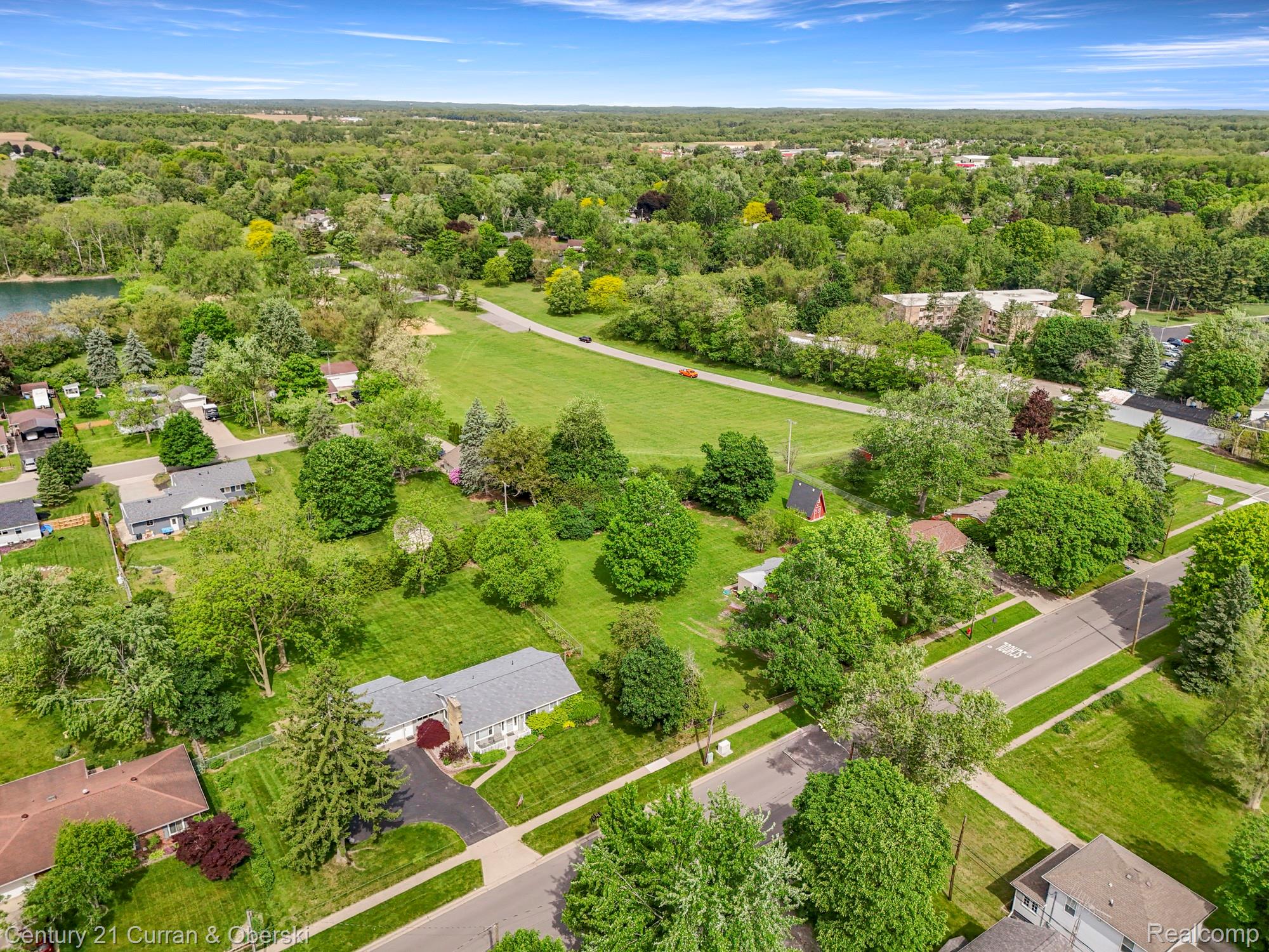 411 South Adrian Street Tecumseh, MI 49286 - Photo 59 of 61 Aerial perspective of suburban area featuring a heavily wooded area and a large body of water