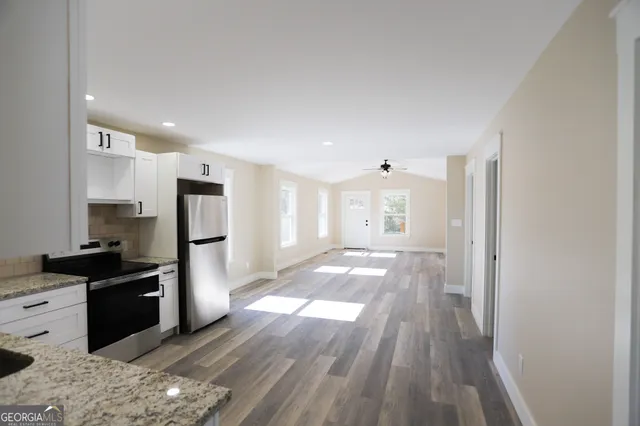 a view of an empty room with a window and wooden floor