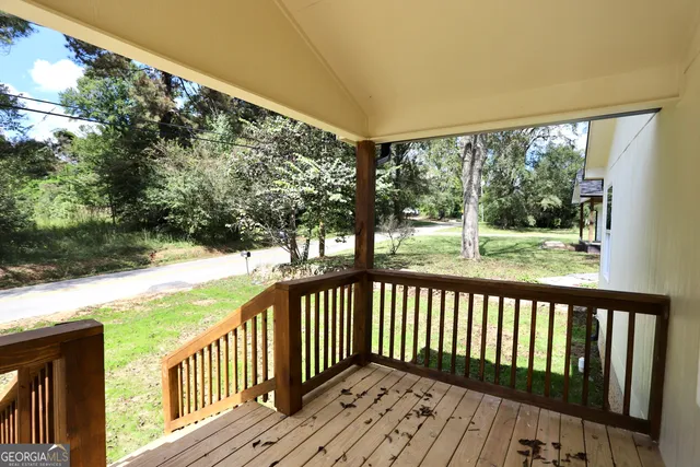 a view of a wooden deck next to a yard with wooden fence