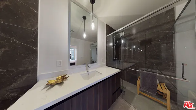 a bathroom with a sink shower and a mirror