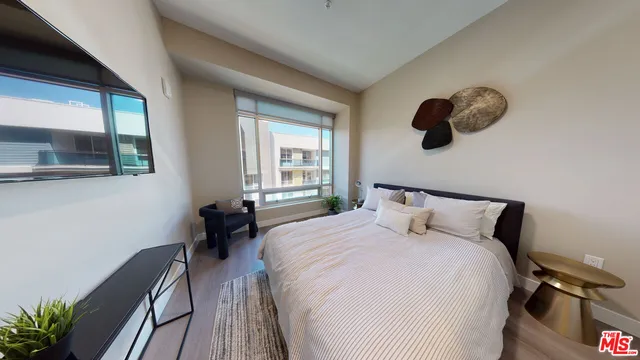 a bedroom with a large bed and a large window