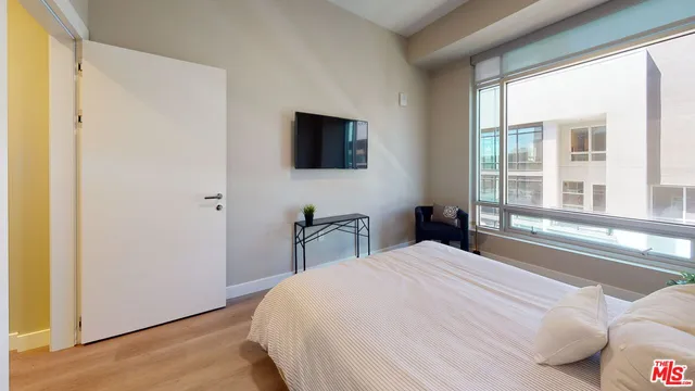 a bedroom with a bed and a flat screen tv