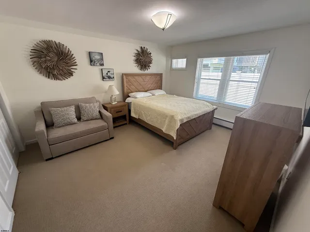 a bedroom with a large bed couch and window
