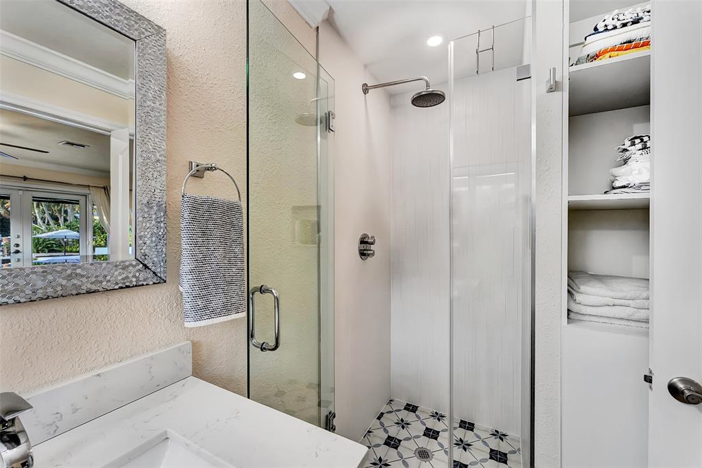 1500 Northeast 24th Street Wilton Manors, FL 33305 - Photo 27 of 88 a bathroom with a granite countertop sink a shower and a mirror
