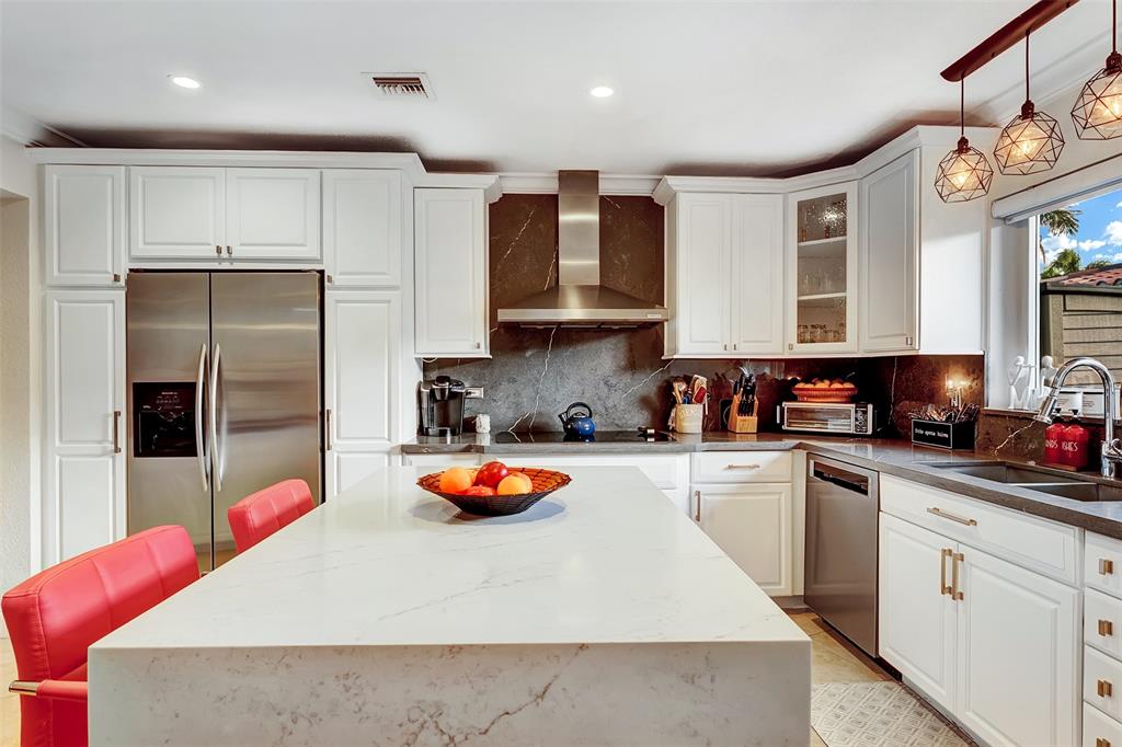 1500 Northeast 24th Street Wilton Manors, FL 33305 - Photo 32 of 88 a kitchen with stainless steel appliances granite countertop a sink refrigerator and cabinets